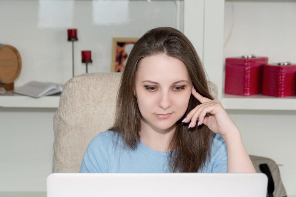 mulher olha para o computador e avalia dívidas prescritas